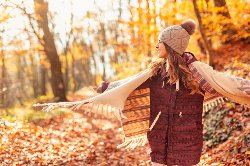 female walking in fall colored forest